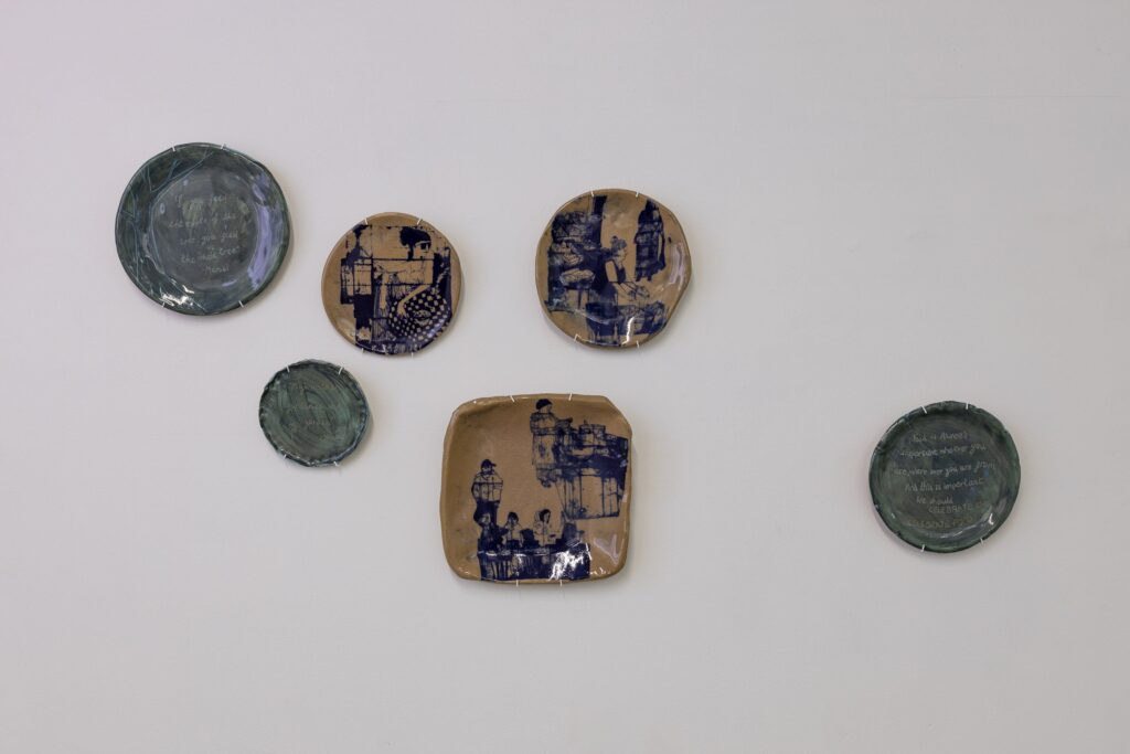 Handmade plates hung on the wall of a gallery