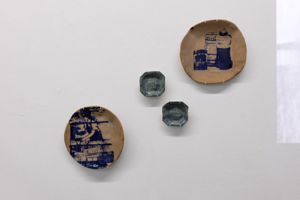 Handmade plates hung on the wall of a gallery